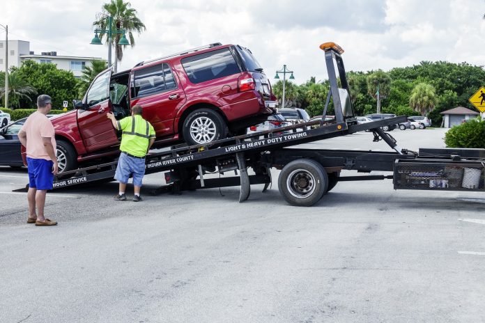 Florida, Vero Beach, flatbed tow truck with red SUV towing all wheel drive