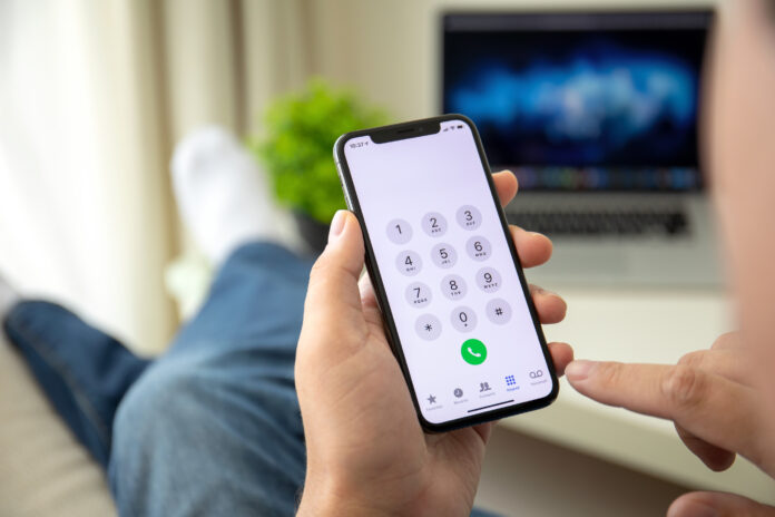 Man hand holding iPhone X with call number on screen is my phone unlocked